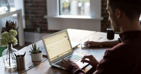 man typing on laptop